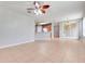 Open living area with tile flooring, ceiling fan, and access to kitchen at 2745 Shearwater St, Clermont, FL 34711