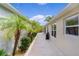 Exterior view of the home featuring a backyard lined with palm trees and manicured landscaping at 2987 Kramer Ct, The Villages, FL 32163