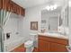 Bright bathroom features a tub-shower, wood-look flooring, and a vanity with a sink and storage at 2987 Kramer Ct, The Villages, FL 32163