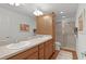 Bathroom featuring a double vanity sink, wood cabinets, and a walk-in shower at 2987 Kramer Ct, The Villages, FL 32163