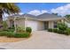 This charming home boasts a two-car garage, well-manicured lawn, and inviting front entrance at 2987 Kramer Ct, The Villages, FL 32163