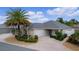 Charming single-story home with a well-manicured lawn, mature landscaping, and an attached two car garage at 2987 Kramer Ct, The Villages, FL 32163