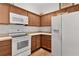 Well-lit kitchen with wood cabinets, modern white appliances, and beige countertops at 2987 Kramer Ct, The Villages, FL 32163