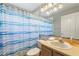 Bathroom featuring blue striped shower curtain, white toilet and vanity, and a large mirror at 3310 Osprey Hill St, Clermont, FL 34714