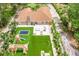 Aerial view of backyard showcasing playground, patio, outdoor seating, and expansive green space in a private, landscaped setting at 33943 E Lake Joanna Dr, Eustis, FL 32736
