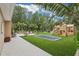 Serene backyard with a play area, artificial turf, and outdoor seating, ideal for Gathering gatherings and relaxation at 33943 E Lake Joanna Dr, Eustis, FL 32736