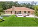 Spacious backyard with artificial turf, outdoor seating area, slide, and trampoline offering a fun and relaxing outdoor experience at 33943 E Lake Joanna Dr, Eustis, FL 32736