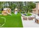 Backyard featuring playhouse, outdoor seating, and artificial turf, designed for Gathering entertainment and relaxation at 33943 E Lake Joanna Dr, Eustis, FL 32736