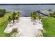 Aerial view of a waterfront property featuring a sandy beach, palm trees, and a private pier at 33943 E Lake Joanna Dr, Eustis, FL 32736