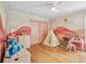 bedroom featuring mural, wood floors, ceiling fan, and pink closet doors at 33943 E Lake Joanna Dr, Eustis, FL 32736