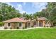 Inviting single-story home with well-maintained lawn, featuring palm trees and mature landscaping, exuding curb appeal at 33943 E Lake Joanna Dr, Eustis, FL 32736