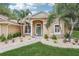 Welcoming front entrance with arched doorway, manicured landscaping, and well-kept lawn offering a pleasant curb appeal at 33943 E Lake Joanna Dr, Eustis, FL 32736