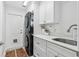 Efficient laundry room with updated appliances, white cabinetry, and a utility sink at 33943 E Lake Joanna Dr, Eustis, FL 32736