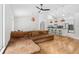 Inviting living area showcasing hardwood floors, a comfortable sectional sofa, and an open layout to the kitchen at 33943 E Lake Joanna Dr, Eustis, FL 32736