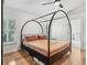Relaxing main bedroom with a canopy bed, hardwood floors, and natural light from shuttered windows at 33943 E Lake Joanna Dr, Eustis, FL 32736