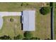 Aerial view of house featuring gray roof, green grass, driveway and mature trees at 4 Kristin Ln, Eustis, FL 32726