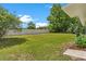 Green grass in large backyard with white vinyl fence and mature landscaping at 4 Kristin Ln, Eustis, FL 32726