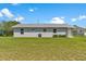 The home is grey brick with a green lawn and white trim on the windows at 4 Kristin Ln, Eustis, FL 32726