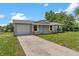 Charming single-story home with a light gray exterior, a well-maintained lawn, and a paved driveway at 4 Kristin Ln, Eustis, FL 32726