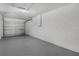 This garage features a white block wall, grey epoxy floor, and a steel garage door at 4 Kristin Ln, Eustis, FL 32726