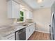 Bright kitchen featuring white cabinetry, stainless steel appliances, and granite countertops at 4 Kristin Ln, Eustis, FL 32726