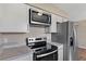 Kitchen showcasing white cabinets, granite countertops, stainless steel appliances and new microwave at 4 Kristin Ln, Eustis, FL 32726
