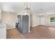 Modern kitchen with stainless steel appliances, light cabinets, a view into the living area, and updated flooring at 4 Kristin Ln, Eustis, FL 32726