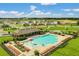 Aerial view of resort-style community pool with splashpad, lounge chairs, and covered pavilion at 424 Noble Ave, Davenport, FL 33837