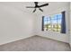 Bedroom featuring neutral carpet, a ceiling fan, a window with curtains, and a door at 424 Noble Ave, Davenport, FL 33837