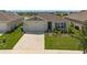 Exterior home featuring a two-car garage, well-kept lawn, and simple landscaping at 424 Noble Ave, Davenport, FL 33837