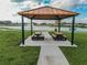 Outdoor picnic area with tables by a pond and water feature in a well maintained park setting at 424 Noble Ave, Davenport, FL 33837