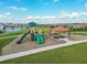 Community playground with slides, swings, and picnic tables overlooking a pond at 424 Noble Ave, Davenport, FL 33837