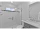 Modern bathroom features tiled shower with glass door, grab bar, and gray vanity at 4346 Pezzullo Cir, The Villages, FL 32163