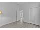 Neutral bedroom with wood floors, closet and view to front entry of home at 4346 Pezzullo Cir, The Villages, FL 32163