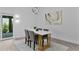 Dining area with modern white table, four gray chairs, and a contemporary light fixture at 4346 Pezzullo Cir, The Villages, FL 32163