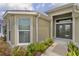 Close-up of home entrance with double glass doors, attractive landscaping, and a cozy, inviting feel at 4346 Pezzullo Cir, The Villages, FL 32163