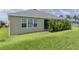 Rear home exterior view shows well-maintained landscaping adjacent to the screened-in patio at 4346 Pezzullo Cir, The Villages, FL 32163