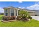 Attractive home with well-kept lawn and landscaping, including palm trees, shrubs, and stone-lined flower beds at 4346 Pezzullo Cir, The Villages, FL 32163