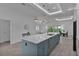 Modern kitchen boasts a large island with quartz countertop and stainless steel appliances at 4346 Pezzullo Cir, The Villages, FL 32163