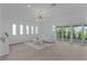 Bright living room featuring a modern sofa, large windows, and access to a patio at 4346 Pezzullo Cir, The Villages, FL 32163
