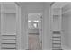 Spacious walk-in closet featuring custom shelving and drawers, leading to a well-lit bathroom at 4346 Pezzullo Cir, The Villages, FL 32163