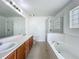 Bathroom features dual sinks, a tub, a shower, and modern fixtures at 439 Gentle Breeze Dr, Minneola, FL 34715