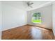 The bedroom features wood floors and a window with a view of the yard at 439 Gentle Breeze Dr, Minneola, FL 34715