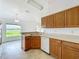 Traditional kitchen featuring wood cabinets, white appliances, and a sink overlooking a window with scenic views at 439 Gentle Breeze Dr, Minneola, FL 34715
