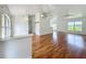Spacious living area featuring gleaming hardwood floors, high ceilings, and abundant natural light from large windows at 439 Gentle Breeze Dr, Minneola, FL 34715