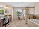Bright bathroom with a soaking tub, tiled shower, vanity area, and large window, providing a spa-like atmosphere at 5144 Rishley Run Way, Mount Dora, FL 32757