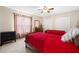 Bedroom featuring two beds with red linens, carpeted floors, and a large window at 5144 Rishley Run Way, Mount Dora, FL 32757