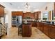Spacious kitchen featuring dark wood cabinets, stainless steel appliances, and a large kitchen island with countertop seating at 5144 Rishley Run Way, Mount Dora, FL 32757
