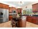 Well-equipped kitchen with dark wood cabinets, stainless steel appliances, and a large kitchen island with barstool seating at 5144 Rishley Run Way, Mount Dora, FL 32757