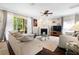 Comfortable living room featuring a ceiling fan, fireplace, and sliding glass doors to let in natural light at 5144 Rishley Run Way, Mount Dora, FL 32757